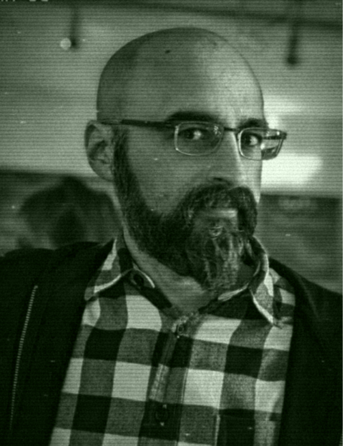Grainy surveillance still of the suspect in a crowded venue